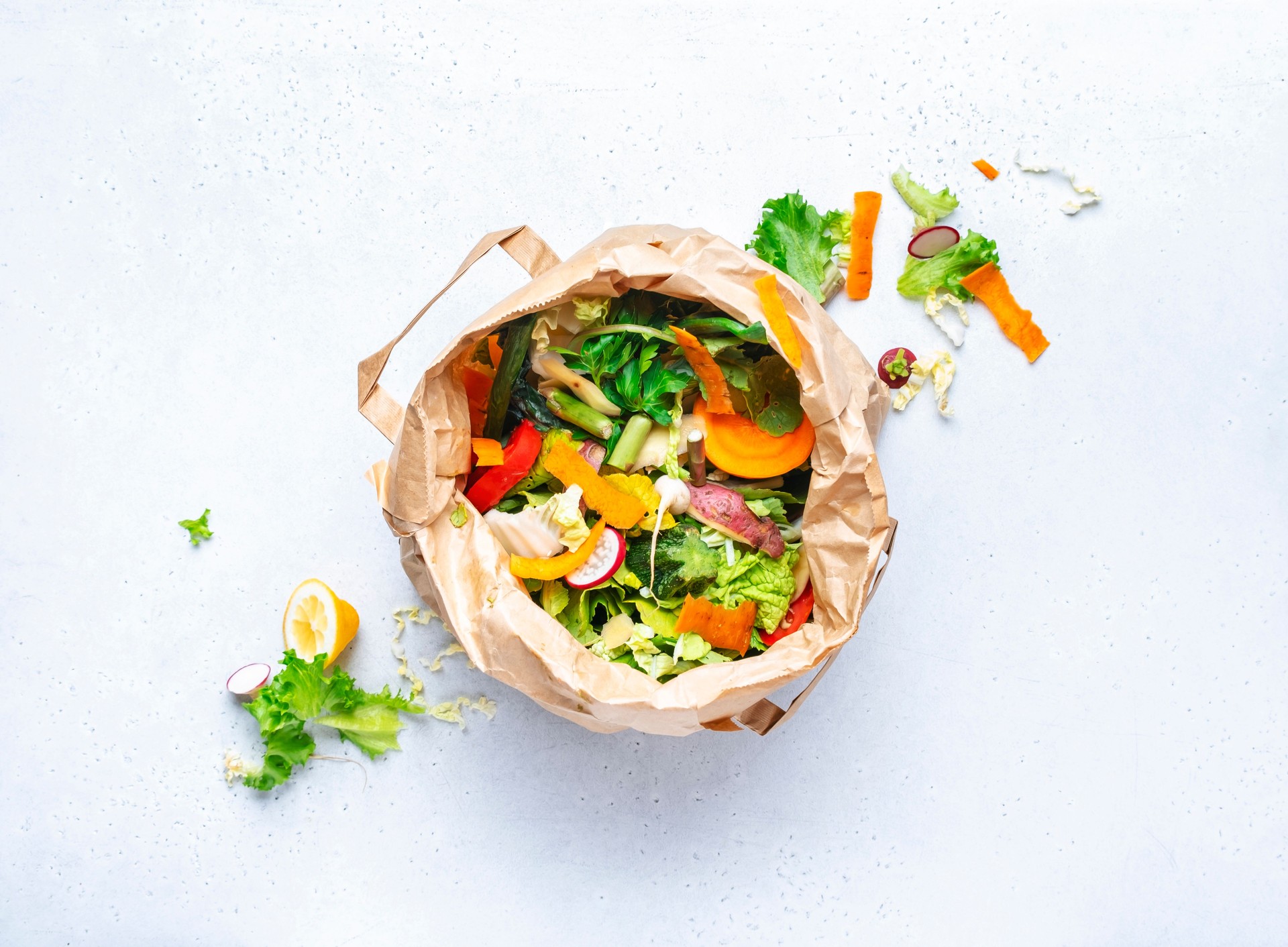 Sorted kitchen food waste in paper eco friendly bag recyclable for garden compost. Sustainable life style, plastic free. Vegetable and fruit peels, scraps from meal preparation